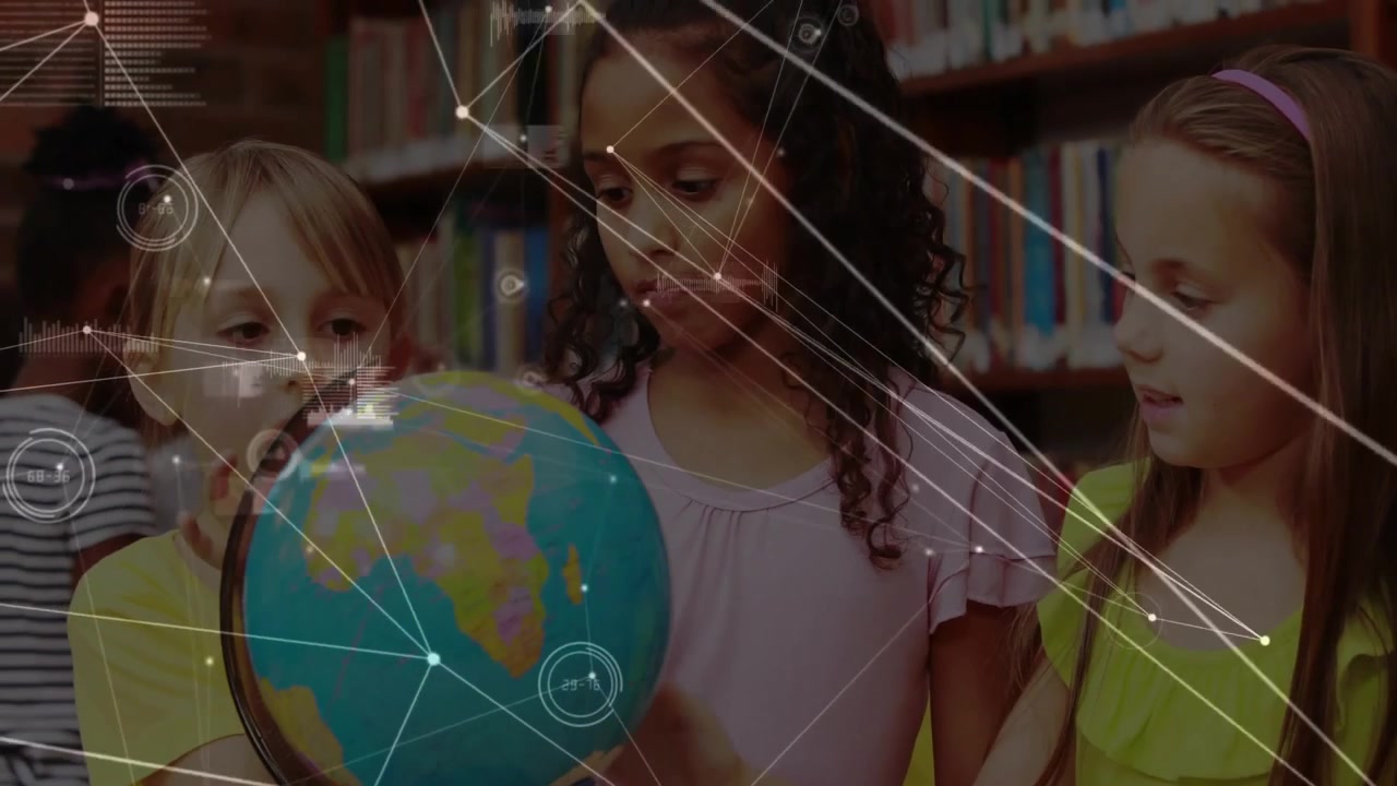 Girls touching globe in library, spinning globe with digital overlays marking regions for geography