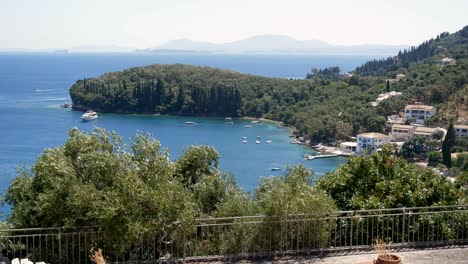 view of forested rocky cliffs on corfu island, beaches, blue sea, and mountains