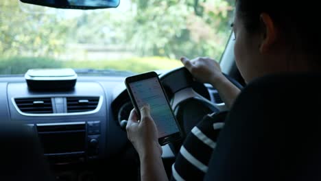 Asian young woman using the Google Maps application on a smartphone to search for directions while driving. Concept of using technology in transportation.