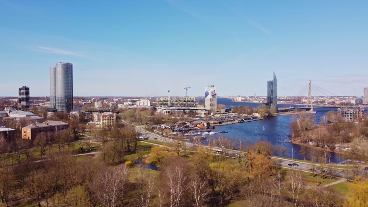 A view over Riga’s cityscape with modern business buildings, the river, and busy street traffic below.