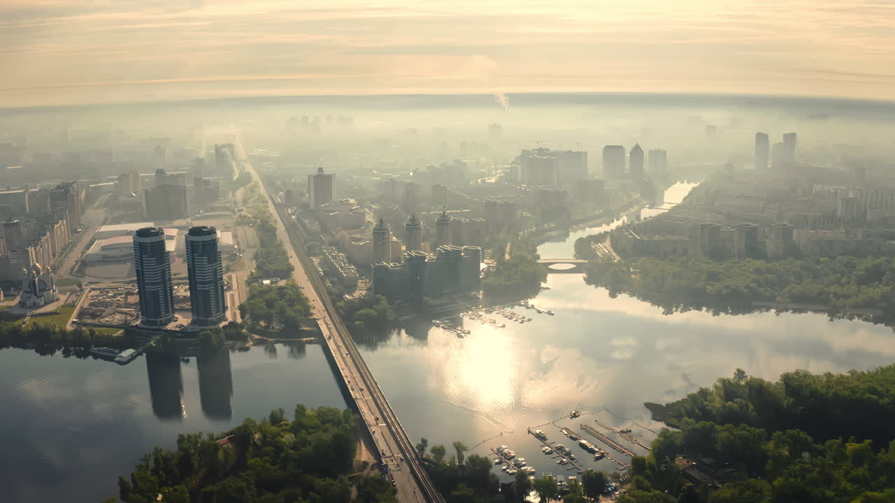 Aerial View of City at Sunrise with River and Bridge