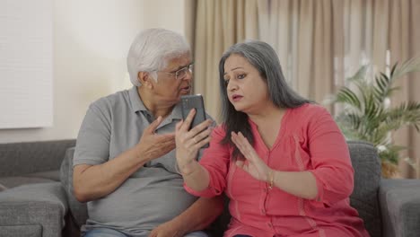 Serious-Old-Indian-couple-talking-on-video-call