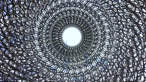 abstract view of a circular metal structure leading towards a white-centered opening
