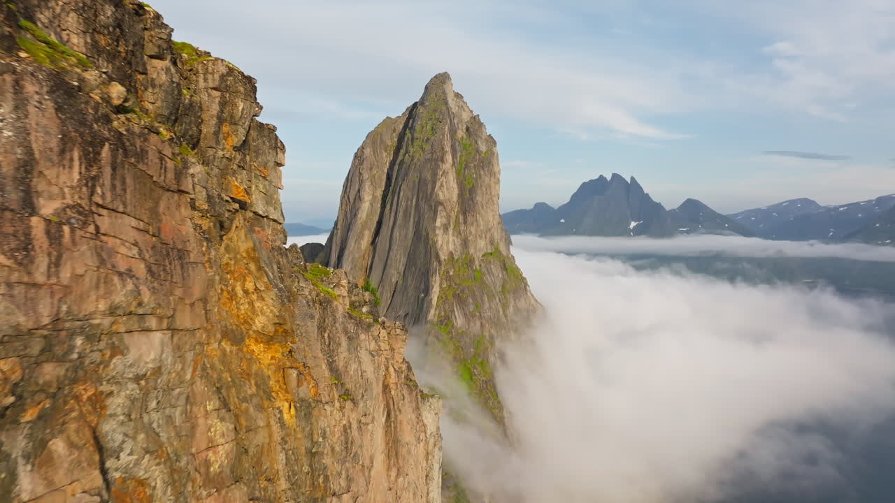 Flight along ridge toward pointed sharp arctic Segla mountain in Norway sunset