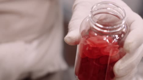 multivitaminas gomosas para la nutrición del cabello embotelladas manualmente con manos enguantadas