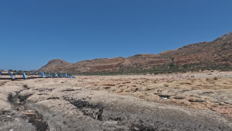tourists at the semi-arid shoreline of balos beach in chania, crete, greece. wide shot