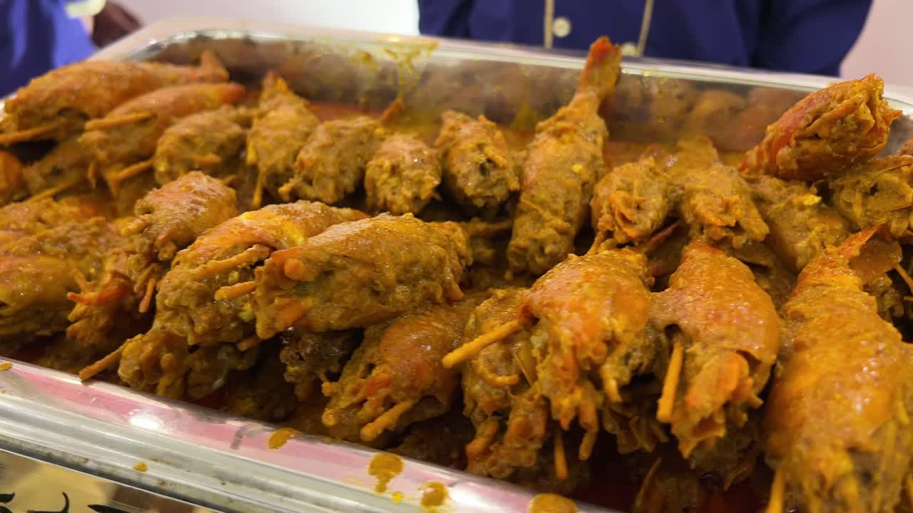 Shrimps or prawns in wooden sticks. Bengali cuisine. Chingri macher malai curry