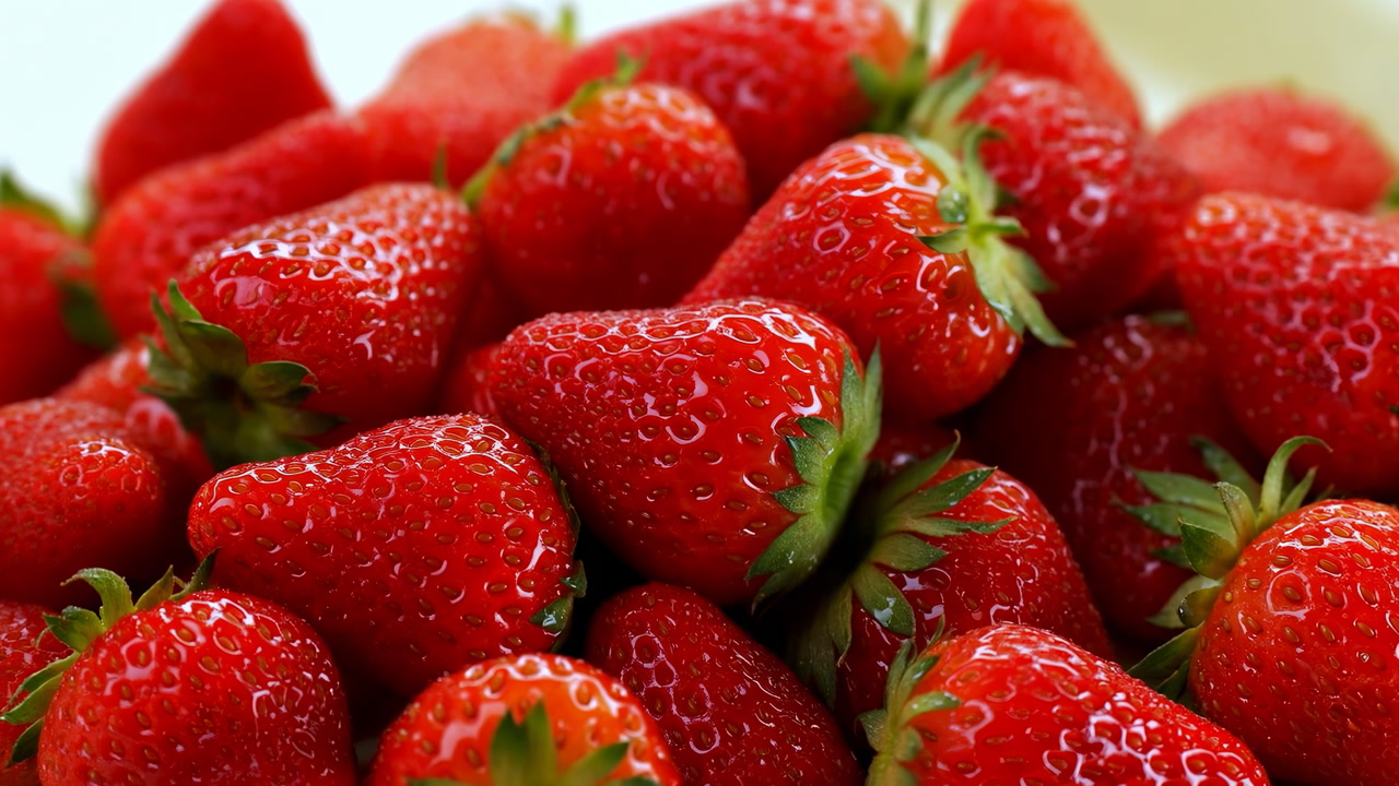 Closeup Fresh Strawberries Piled Glistening Red, Dewy Macro View Of Ripe Berries With Green Calyx, Glossy