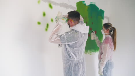 man and girl in protective suits draw stains with sprays