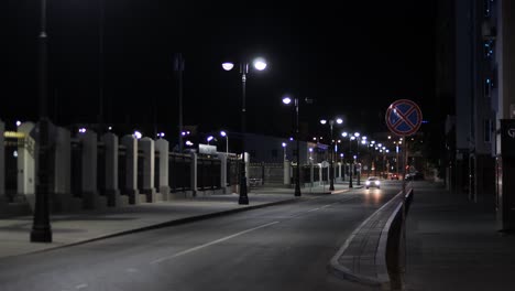 empty city street at night with street lights and no people.