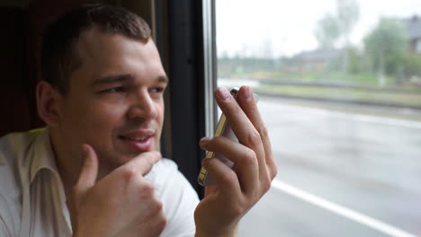 Young-man-typing-sms-in-moving-train