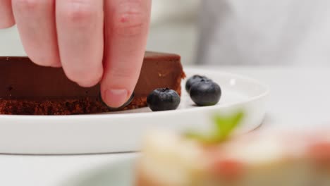 chef placing a piece of chocolate cheesecake