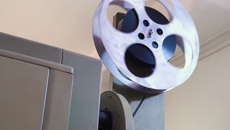 spool with reel rotates on vintage equipment to show movie