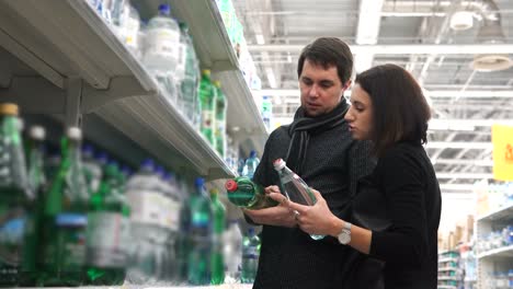 couple shopping for water bottles in a grocery store