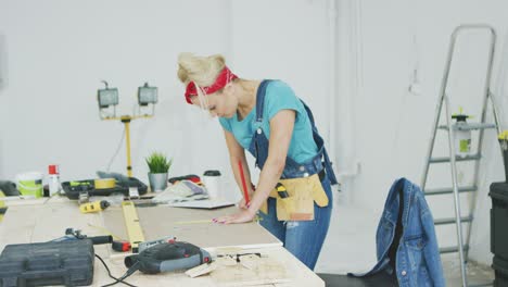 Female-carpenter-drawing-lines-on-plywood-sheet-