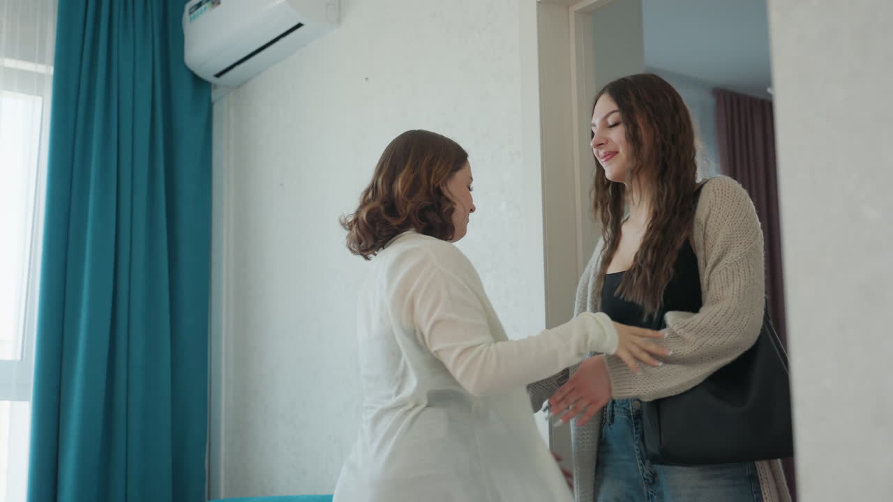 Warm Greetings Exchanged, Women Welcome At Door, Caregiver And Traveler Share Heartfelt Moment At Threshold, Natural Light Highlights Emotional Reunion Between Women At Apartment Entrance
