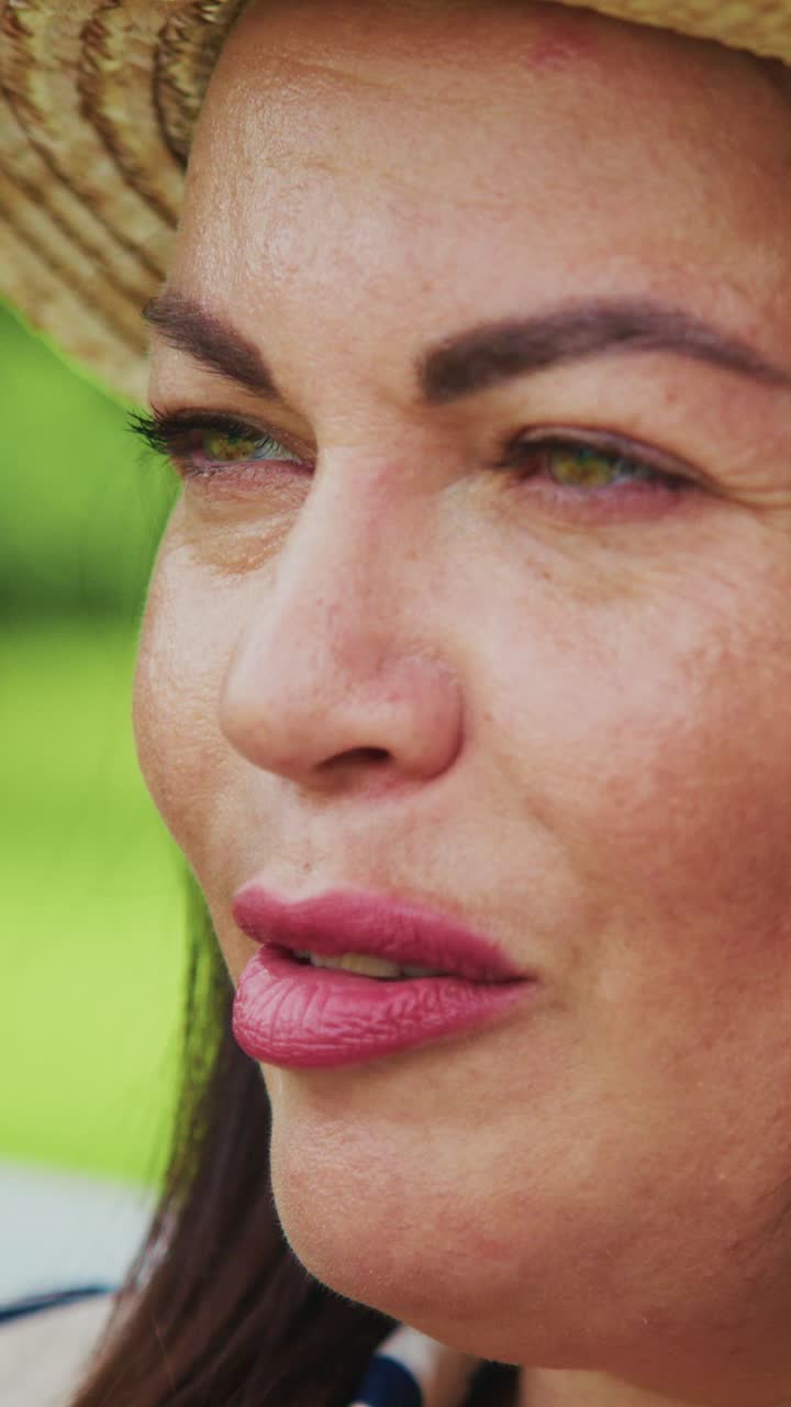 A Close-Up View of a Woman Enjoying a Relaxing Moment Outdoors, Highlighting Her Joy and Serenity with Natural Beauty and a Fashionable Hat