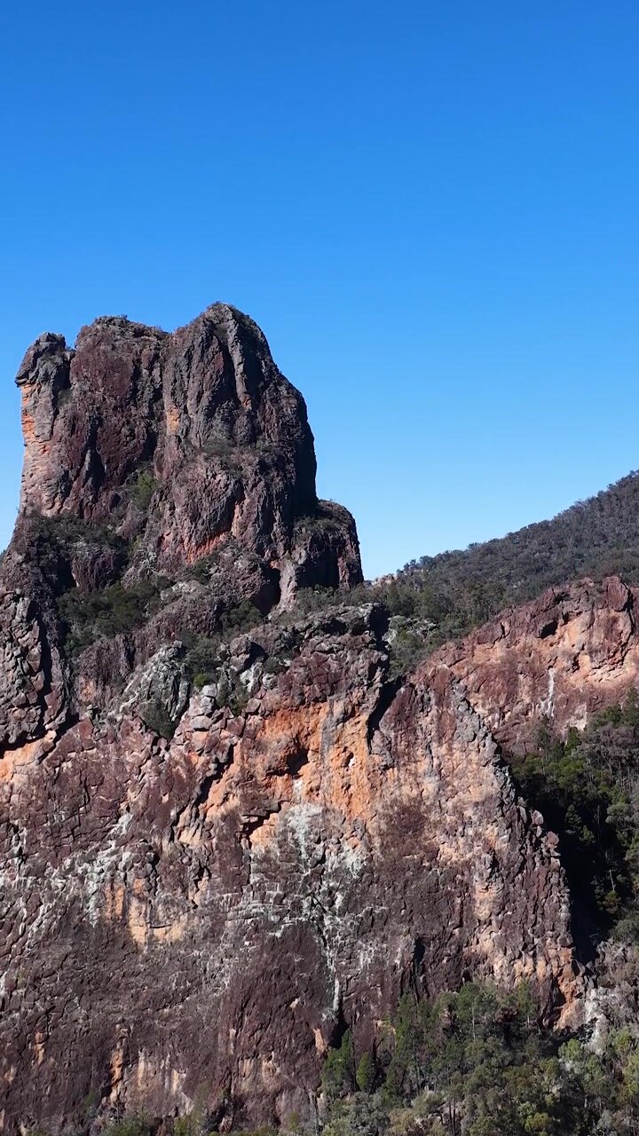 Vista aerea di una vetta montuosa aspra contro un cielo azzurro limpido
