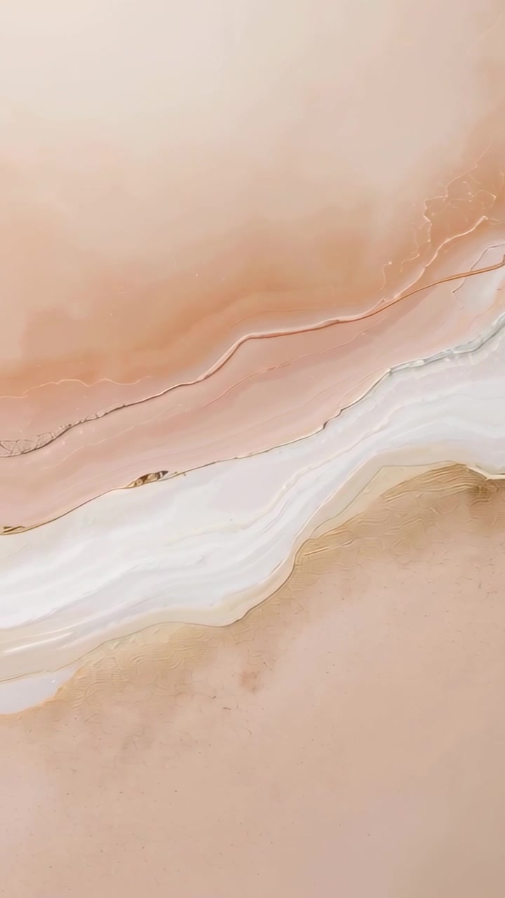 Video verticale: Spostamento di inquadratura con panoramica su una fascia centrale color crema su una pietra in primo piano, che espone venature dorate.