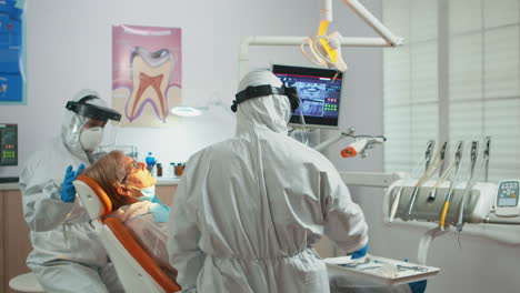 Doctor-in-protection-suit-using-drilling-machine-during-examining