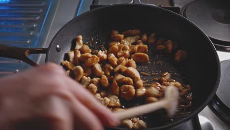 Cooking And Stirring Chopped Chicken Breast In A Skillet With Honey And Soy Sauce