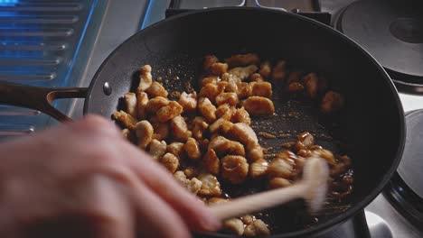 cooking and stirring chopped chicken breast in a skillet with honey and soy sauce