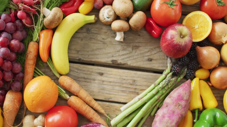 Video of fresh fruit and vegetables with heart shaped copy space over wooden background