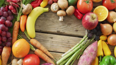 Video-of-fresh-fruit-and-vegetables-with-heart-shaped-copy-space-over-wooden-background