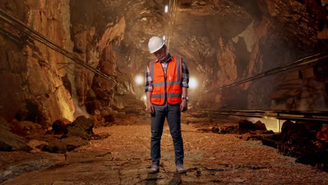 full body of asian male engineer with safety helmet having a headache while working in underground mine tunnel
