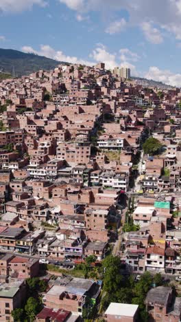 drone shot capturing the vibrant neighborhood of comuna 13, highlighting its densely packed houses and lively atmosphere. vertical video