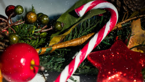 animation of snow falling over candy cane christmas decoration