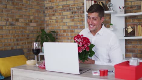 Hombre-Caucásico-Haciendo-Videollamada-Usando-Una-Computadora-Portátil-Sosteniendo-Un-Ramo-De-Flores-Y-Sonriendo