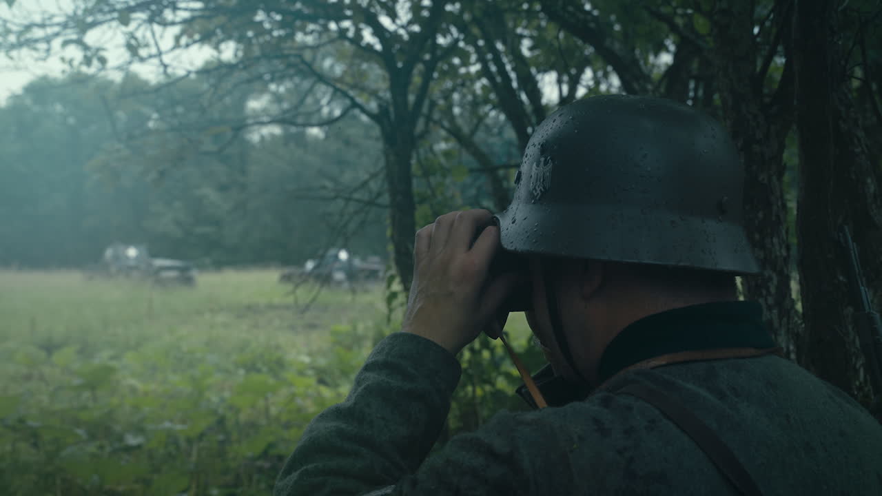 German soldier observing the battlefield during a war, likely World War II