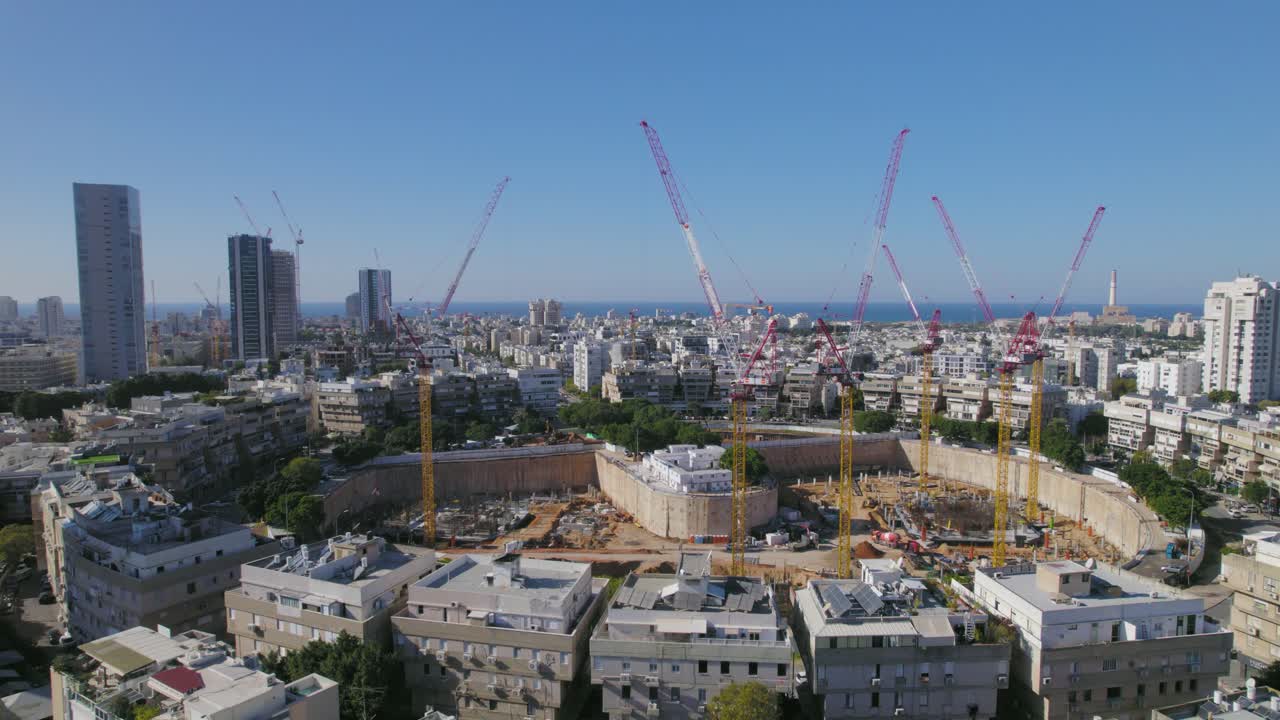 paralaje desde baja altura y detrás de los edificios residenciales alrededor de una gran plaza de la ciudad que está en construcción