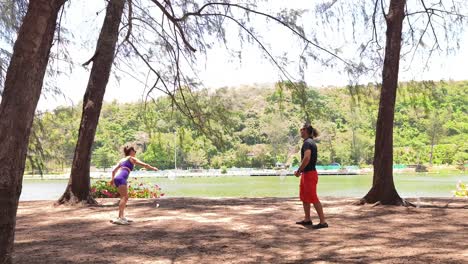 couple playing badminton by the lake
