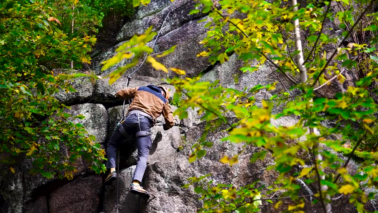 Male use harness around waist for safety to climb steep cliff, Czechia