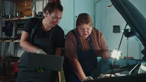 women mechanics inspecting a car in a garage