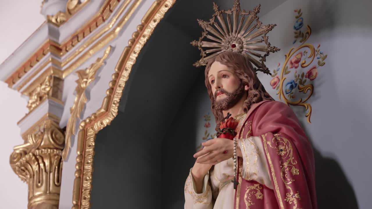 Statua di Gesù con Sacro Cuore in un altare ornato con dettagli in oro e floreali