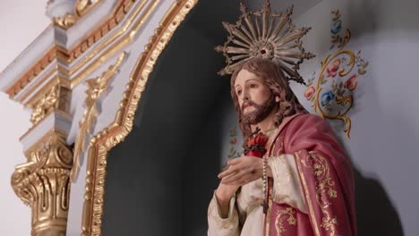 statue of jesus with sacred heart in ornate altar with gold and floral details