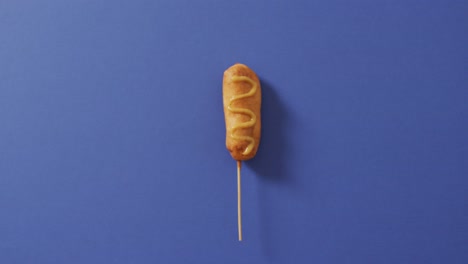 video di corn dog con senape su una superficie blu