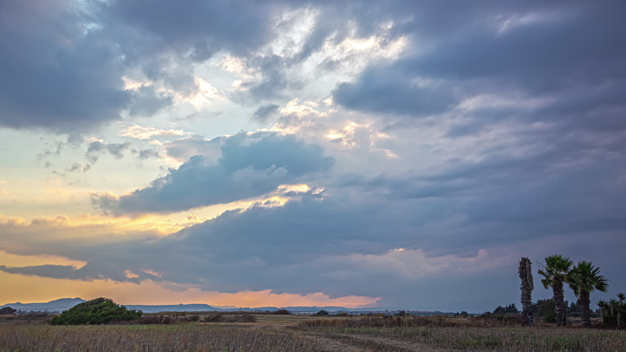 This timelapse captures the enchanting spectacle of cloud movements against the backdrop of a sky illuminated by the radiant golden light of the sun