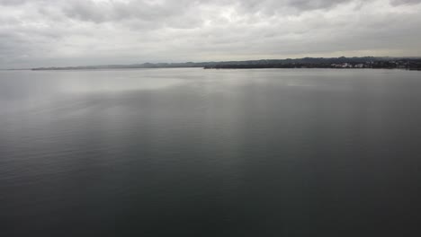 Aerial-view-of-Lake-Constance,-a-happy-cloudy-autumn-day,-in-the-background-the-country-of-Germany-and-forest-on-the-shores,-Bregenz,-Vorarlberg,-Austria,-Europe