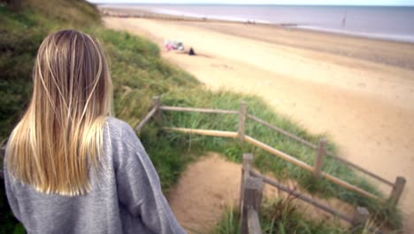 beautiful girl walking down the stairs in the beach