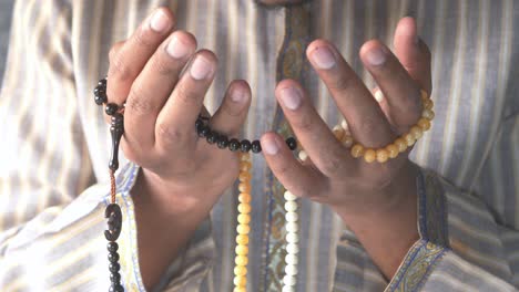 muslim man praying with prayer beads