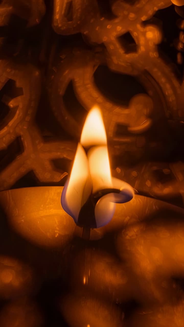 Vertical video: After wick lighting, flame flickering at temple altar, illuminating ornate lattice
