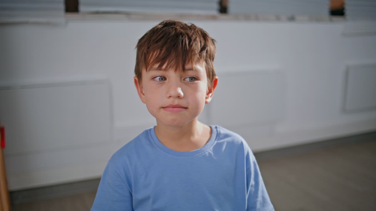 Small pupil looking camera sitting lesson classroom portrait. Schoolboy posing