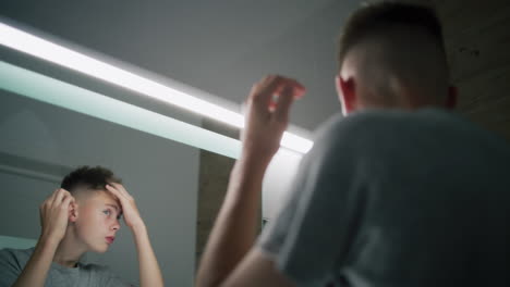 teenage boy looking in the mirror