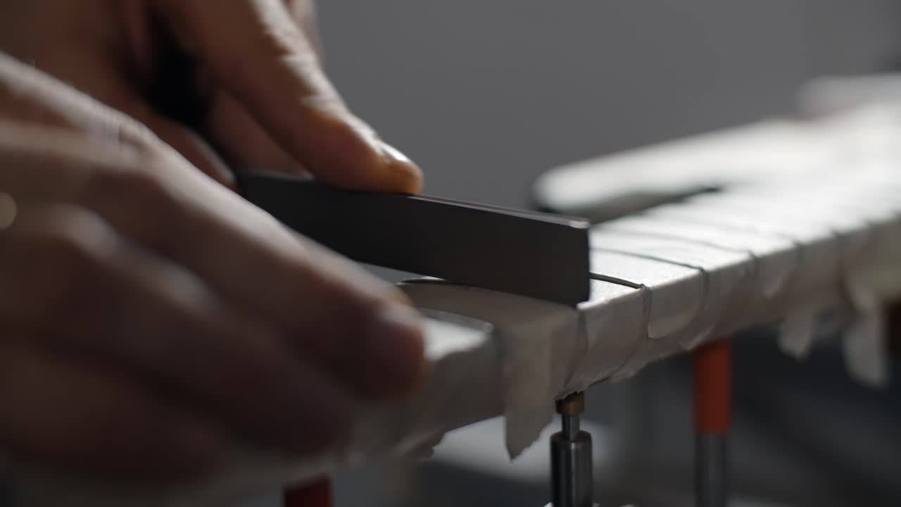 Close-up view of someone sanding wood with a file