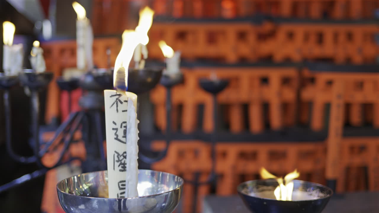Fushimi Inari Shrine in Japan with candles flickering gently, illuminating inscriptions and creating a peaceful atmosphere. Translation on candle: ''Inari - God of Rice''