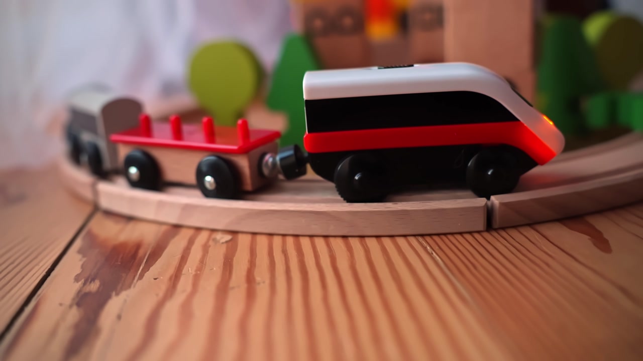 Wooden toy train rolling on a curved track over pine tabletop, cozy indoor nursery scene with shallow depth of field—childhood learning, imagination, and screen-free play.